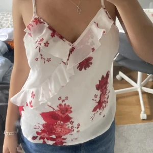 Blommig volang topp  - Super gulligt linne med volanger och fina röda blommor på. 