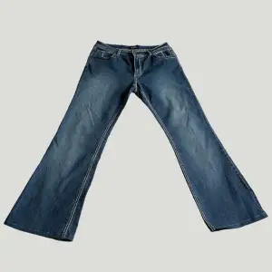 Unika bootcut jeans med fickor baktill & vita sömmar. I princip nyskick! Midja: 49x2, innerben: 80cm, yttre: 100cm