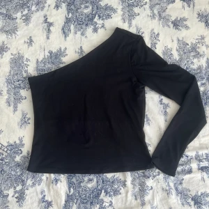 Enärmad topp - En ärmad topp från hm i storlek M. Fint skick, superlite kattklös (och hår) på magen men som ni ser på utzoomade bilden syns detta knappt