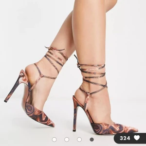 Snygga klackskor med snöre  - Bruna, virvelmönstrade, höga klackskor med knytning runt benet. 