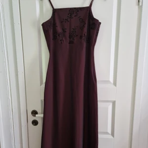 Bal/aftonklänning - Bal/aftonklänning i mörkröd. Formar sig efter kroppen jättefint. 
