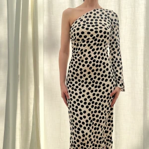 Prickig asymmetrisk lång klänning  - Prickig asymmetrisk lång klänning. Simkesmaterial, använd en gång. 