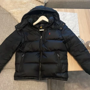 Ralph Lauren jacka  - Tjena Säljer nu denna riktigt snygga Ralph lauren jackan. Den är köpt på Kidsbrandstore för ca 2 månader sedan för lite mer än 2900kr. Jackan är i nyskick, den har inga hål eller liknande och dragkedjorna fungerar hur bra som helst. Stl 14-16