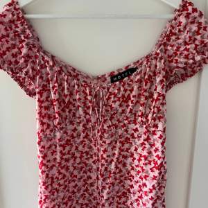 Jättefin rosa/röd klänning med små fjärilar från Motel Rocks. Använd fåtal gånger och är i bra skick!💓