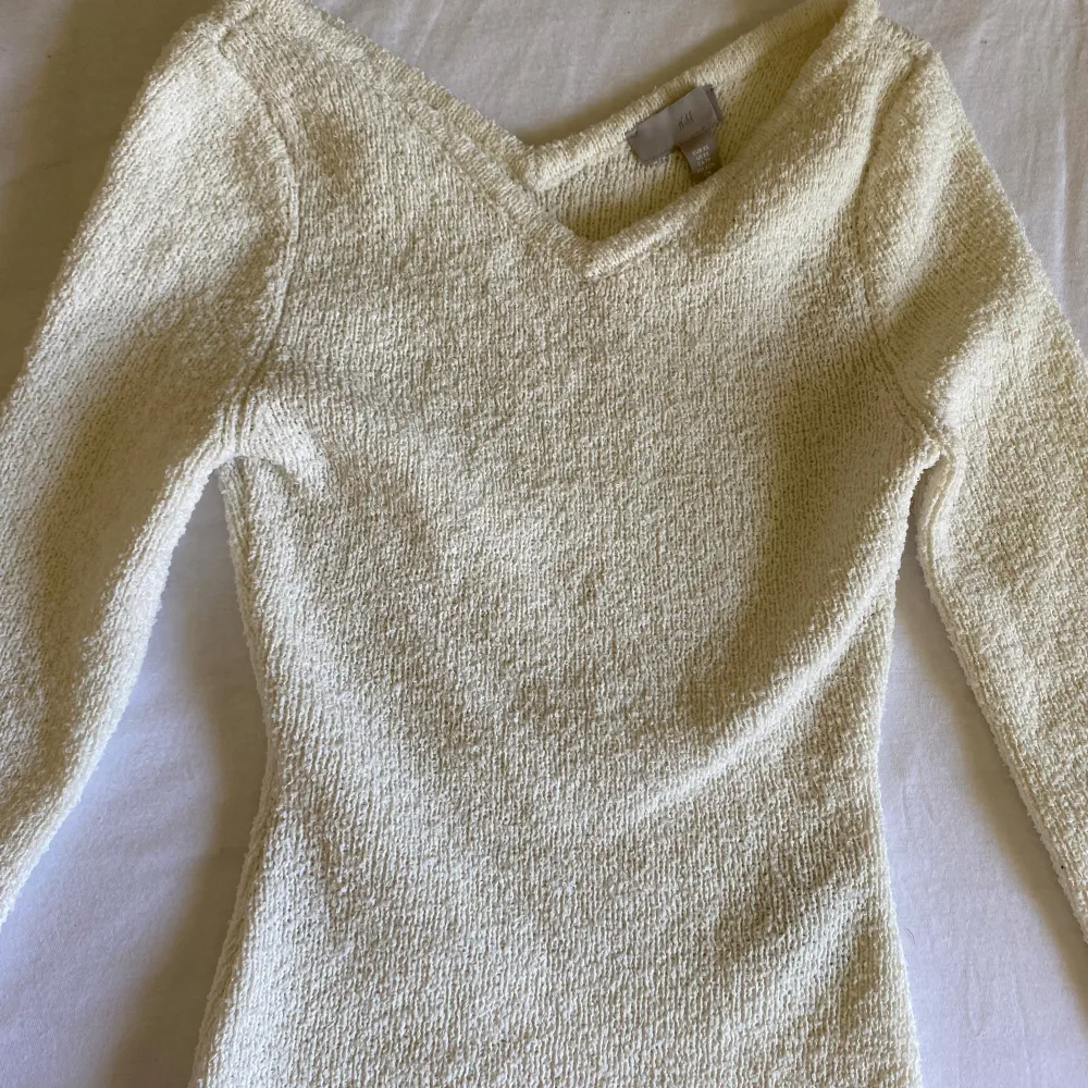 Gräddvit tröja från H&M i handduksmaterial! Den är lite V-ringad både fram och bak och har slits i ärmarna. Storlek S och använd en gång, nyskick!!. Neuletakit & Villapaidat.