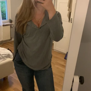 Grå långärmad tshirt - En långärmad grå T-shirt. Lite oversized passform. Tunnt och skönt material. Jättefint tryck på bröstet samt knappar vid halsen. Den har även ett medvetet hål vid armen.🤍