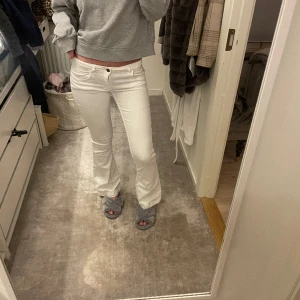 Vita jeans med coola detaljer  - Jeans med coola detaljer. Midjemått 37 cm rakt över, innebenslängden 81 cm