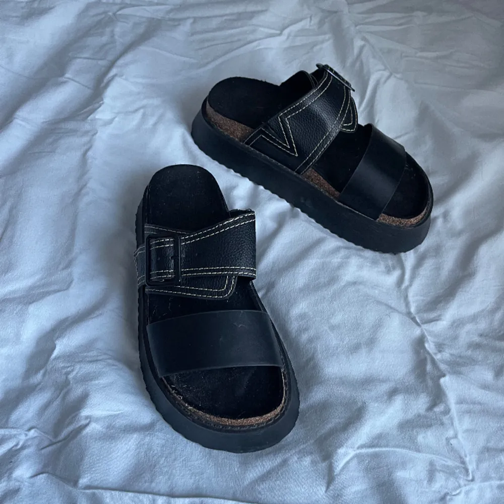 Svarta, platta sandaler med två remmar och formad sula. Jättesköna att gå i!!!🌟🌟  Använd 1 gång:/ . Skor.