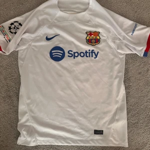 Nike tröja  - Barcelona borta tröja. Araujo 4#. Ny skick, Champions league loggan på sidan. I Large 