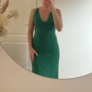 mörkgrön långklänning - perfekt som balklänning! banden där bak kan man knyta lite hur man vill