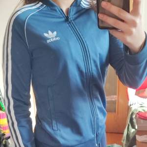 En as cool äkta adidas zip up hoodie utan luva😍😍 Sitter jätte snyggt och har inga defekter vad jag kan se!!