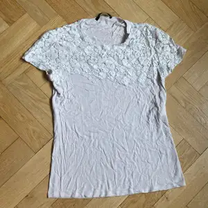 Det är en beige/vit tröja med spets från Marc Aurel i storlek 38.