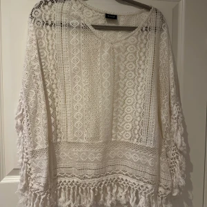 Häftig spetsig tröja  - Mycket bra skick  Lite som poncho, det finns inga ärmar. Färgen är som äggskal/gräddvit  Lite tjockare tyg  Storlek är M men passar även L 