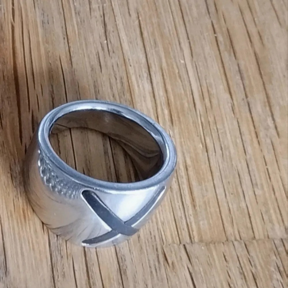 Ring i rostfritt stål, märke fossil.  max. centimeter. 1.6 avsmalnande med ett brunt läder x som design i mitten. Ring storlek 17.(16,9mm) . Accessoarer.