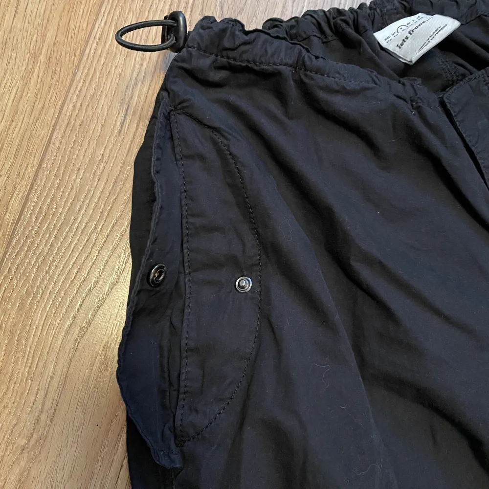 svarta parachute byxor från Urban Outfitters i storlek Small! Går att justera i midjan och längst ner. Inga större tecken på användning, har använts ca 4 gånger.. Jeans & Byxor.