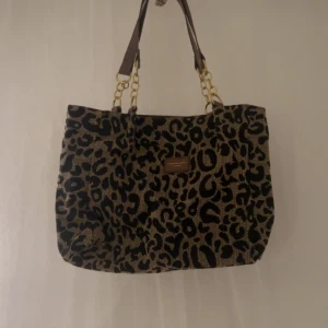Leopard väska - En jättefin väska med fina leopard mönster. Den är i nyskick och har aldrig använts. Säljer för att jag inte hittar användning till den.
