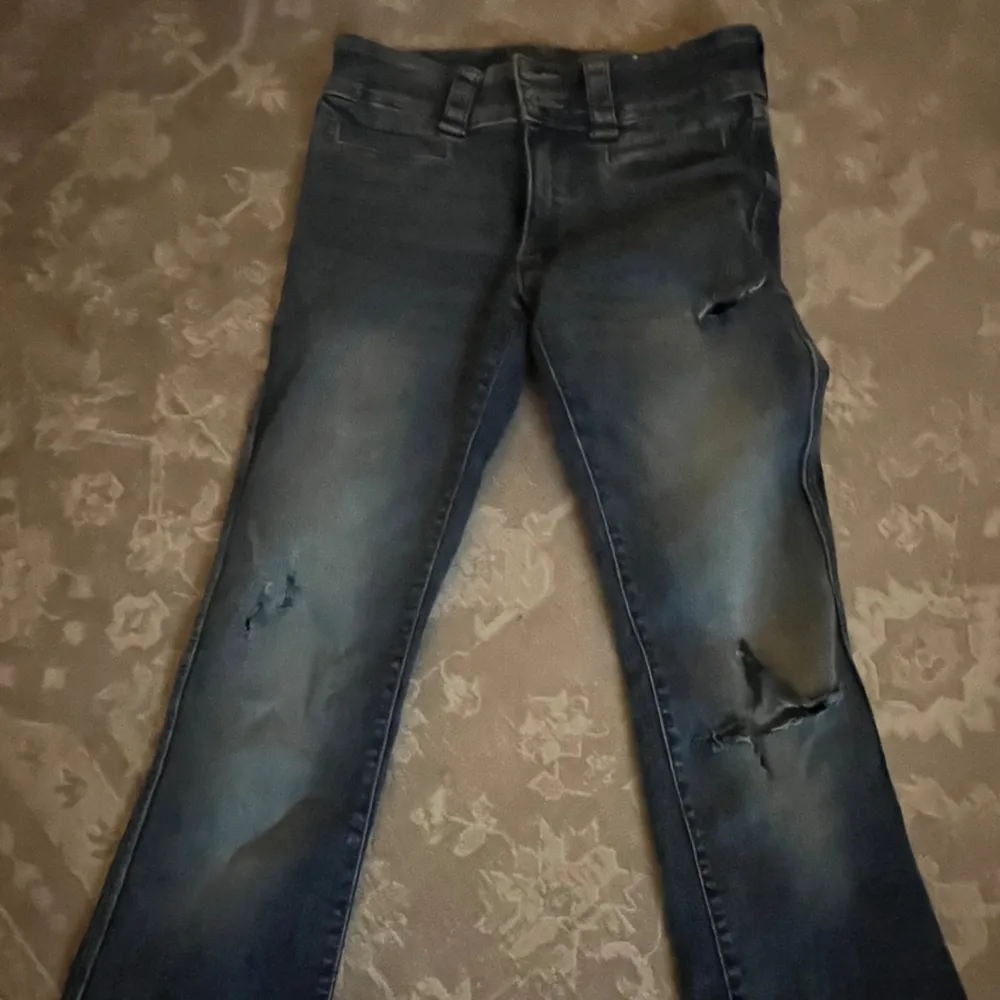 Skitsnygga bootcut lowwaist jeans från hm. Har klippt hål sjölv, har knappar med fickor (se bild 3). Jättebra skick och knappt använda. Går att justera i midjan. Passar nån som är 155-162 skulle jag säga❤️❤️❤️ pris kan diskuteras! . Jeans & Byxor.