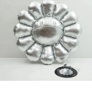 KAWAII  - En silverfärgad kudde i form av en blomma från Kawaii Kids Co. Kudden har ett glatt ansikte broderat på framsidan och är tillverkad av ett glänsande material. ÄKTA!!