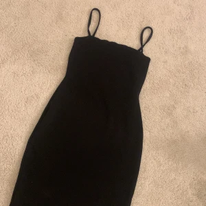 Svart tajt klänning från Nelly  - En svart kort klänning som nästan är helt oanvänd. Fint skick!😊