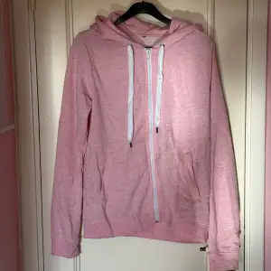 En bekväm rosa hoodie med dragkedja framtill. Hoodien har långa ärmar, en huva med vita snören och två fickor på framsidan. Köpt från H&M längesen. Står inte storlek men tror det är en S. Katter finns i hemmet