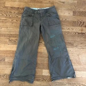 Coola byxor  - Coola byxor med broderi på benet. Märke är Fat face, midjemåttet är 40 cm och innerbenslängden är 70 cm. Dem har dragkedja på benen. Dem är lite utsvängda och är i fint skick.