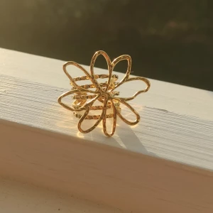 Guldfärgad ring med blomdesign - En elegant guldfärgad ring med en unik blomdesign. helt oanvänd. justerbar storlek 