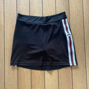 J-Lindeberg Kjol - Svart med randig detalj och ficka bak. XS-S