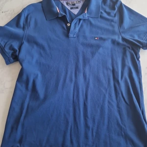 Tommy hilfiger piké  - Jättefin blå pikétröja till sommaren. Använd men mycket bra skick, storlek L men slim fit (passar M)