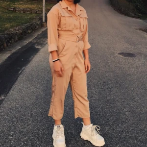 Jumpsuit  - Svart jumpsuit från NA-KD med fickor uppe och nere Benen är något korta i modellen 