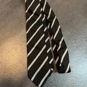 Svart/vit randig slips från H&M.