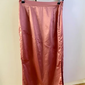 Rosa satin liknande kjol NAKD - Kjol i strl 36 i maxi modell. Slits på vänster sida. 