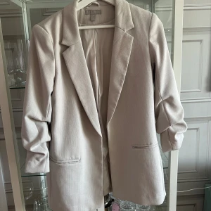 Beige kavaj - Superfin kavaj från H&M sendan något år tillbaka men sparsamt använd. Uppsydd i ärmarna. 