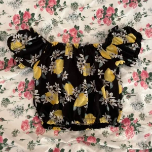 Off-shoulder blus - En kort svart off-shoulder blus med motiv av citroner från Ginatricot i strl XS!💓