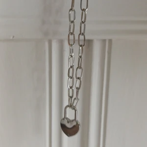 Halsband - Silverfärgat halsband. Relativt tjock kedja med hjärta. Justerbar kedja. Köpt på HM. Köpt för 60 kronor. Helt oanvänd