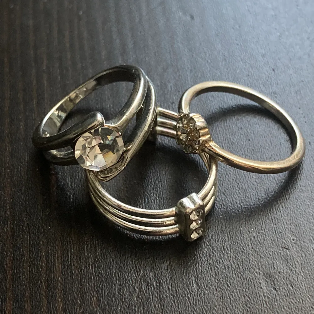 Tre silverfärgade ringar med strass. Innerdiameter: 17 mm, 16 mm och justerbar, bredd: 6 mm, 10 mm och 7 mm.. Accessoarer.