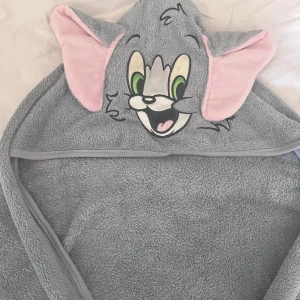 Badcape Tom&Jerry - Tom&Jerry badcape till barn. Skulle säga storlek är mellan 3-6 månader ungefär. Aldrig använd!