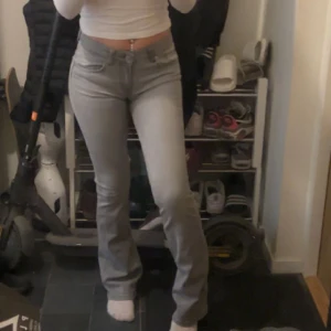 Gråa low waist bootcut jeans - Säljer ett par gråa lågmidjade utsvängda byxor som är i nyskick!🤍 Jag är 164cm och de är lite längre än mig. Byxorna är i storlek Xs och ifrån lager 157 så mått går att kolla upp.