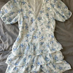 Vit lila blommig zara klänning - Säljer denna jättefina klänningen. Perfekt skick och väldigt trendig. Perfekt nu till sommaren!