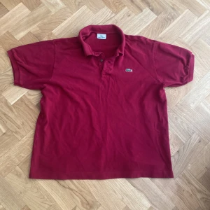 Lacoste piké  - Säljer nu min trendiga Lacoste pike i en väldigt eftertraktad mörkröd färg. Tröjan är i toppskick och har används ett fåtal ggr. Tröjan köptes för 1700 i marbella detta år, säljes nu endast för 250!! 