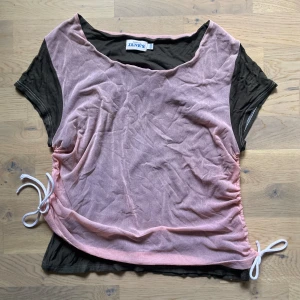 Justerbar Vintage Topp - Vintage justerbar topp med olika lager tyg och mesh. Snörning på sidorna. Färgen är gråaktig och ljusrosa. Det står att det är storlek 42-44, men passar som M.