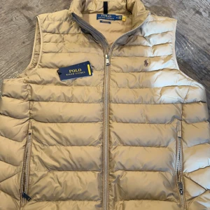 Ralph Lauren Väst - Säljer denna sjukt snygga väst  ifrån Ralph Lauren i färgen Khaki! Säljer då den var för stor. Västen är aldrig använd och då 10/10 skick. Köpt på Ralph lauren för 2600kr säljer för 1199kr. Hör av er vid minsta fråga!