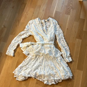Vit spetsklänning - Jättefin vit spetsklänning med see-thru rygg och skärp 🤍 Användes en gång under studenten. Fin V-ringning, längd: mini