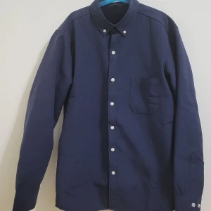 Säljer en marinblå skjorta, helt ny skick och väldigt bra material, den är ganska tjock  - Säljer en marinblå skjorta, helt ny skick och väldigt bra material, den är ganska tjock