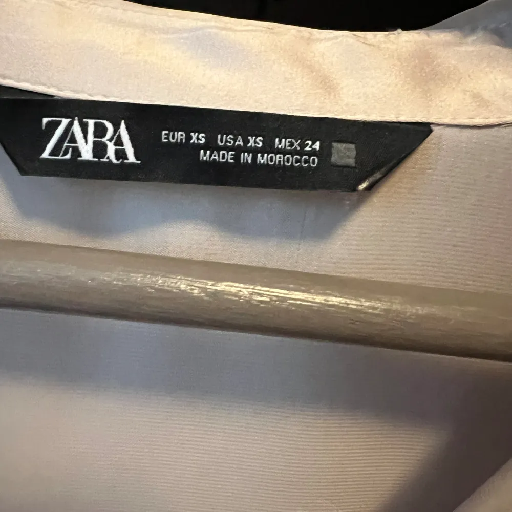 Glansig beige blus från Zara med knappar. Aldrig använd. Storlek XS . Blusar.