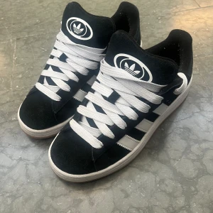 Adidas campus 00s core black - Säljer mina adidas campus 00s som är slutsålda överallt. Låda och svarta skosnören följer med. Säljer då de ej kommer till användning. I princip så gott som nya då jag köpta de förra månaden💗 vid snabb affär kan priset diskuteras.