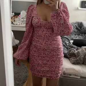 Rosa klänning - Jättefin rosa blommig klänning från Nelly, den är bekväm och endast använd en gång så i gott skick, strl 34, katthushåll