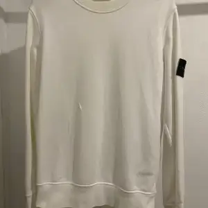 Stone island sweatshirt  Storlek S Säljes då jag köpt en ny, litet hål som på bild nummer 3 inget större. Nypris 2500:- mitt pris pga hålet 700:- + frakt, köpt på NK i Stockholm. Vid fler frågor skriv.