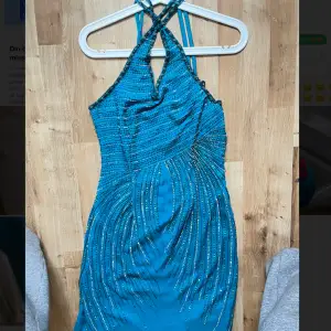 En jättefin blå klänning från märket Prima Donna som är i jättefint skick. Den har fina detaljer med blåa paljetter, ny pris är ungefär 2000 kr. Säljer pga att den är för liten för mig, klänningen är i storlek S