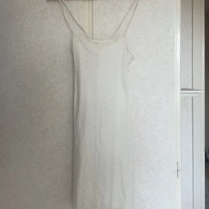 Vit klänning - Vit klänning med öppen rygg, precis ovanför knäna på mig som är 1,68