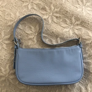 Väska - Super söt blå väska jätte fin till sommaren justerbar axelrem. Köpt för ca 400kr och använd ca 5 pris kan förhandlas ☀️